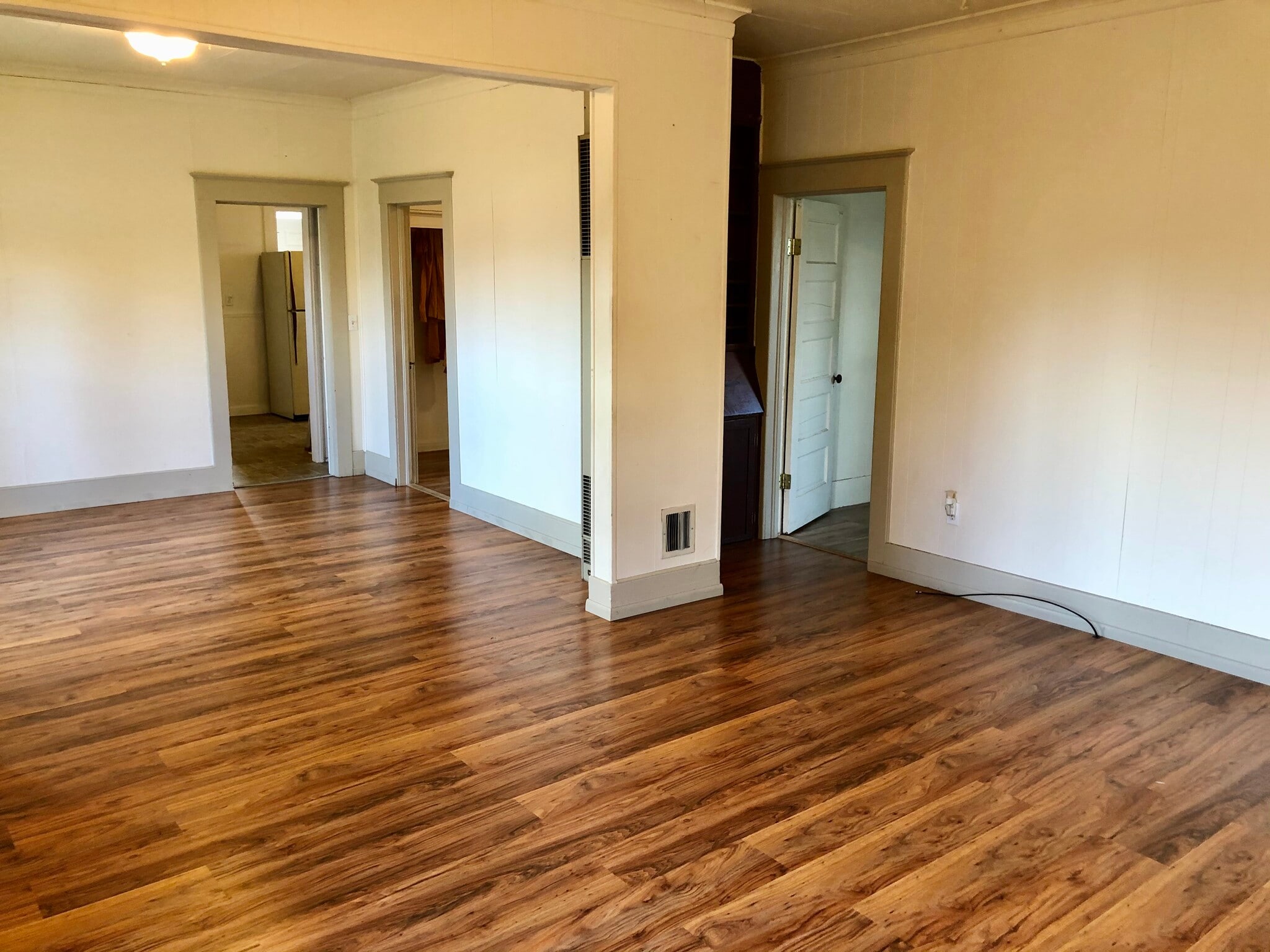 Living room with view of doorway of front bedroom and looking onto dining area and second bedroom doorway - 601 J Street