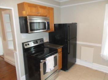 Kitchen with like-new refrigerator, range, and microwave. - 301 S West End Ave