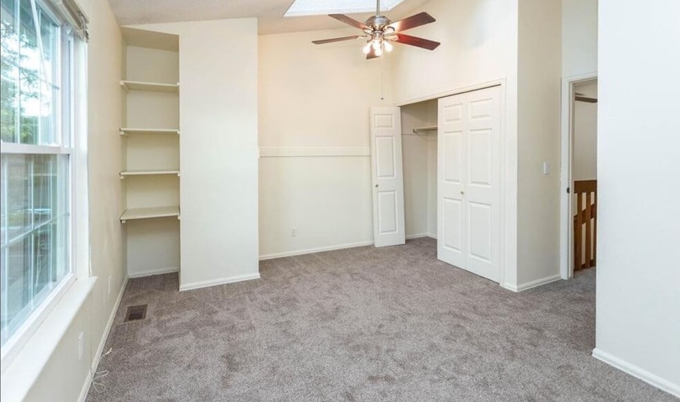 Bedroom with skylight and ceiling fan. - 1953 Giltshire Dr