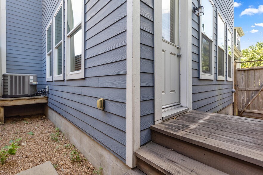 Back patio enclosure for AC and utility access. Graveled, no maintenance area. - 1221 W 23rd St