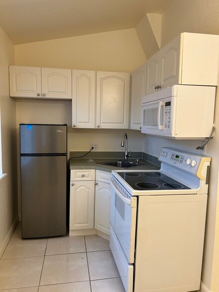 Kitchen with fridge, sink, stove, oven, microwave - 205 Coral Rd