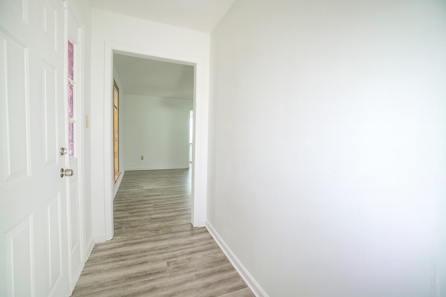 Bright entryway with modern flooring leading to the living room, dining, and kitchen areas. Clean wh - 2313 Salem West Dr