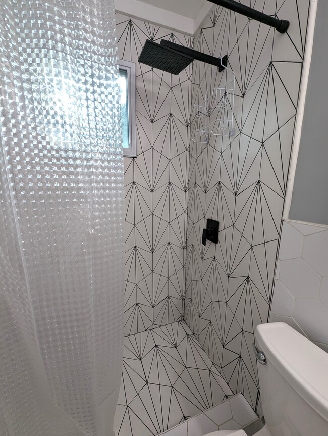 The bathroom is completely updated with custom tile work a rain shower and modern fixtures. - 4107 Crane St