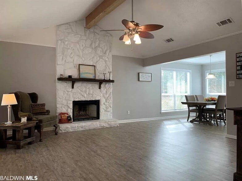 Open concept living/dining area with lots of natural light and wood burning fireplace - 113 Penny Ln