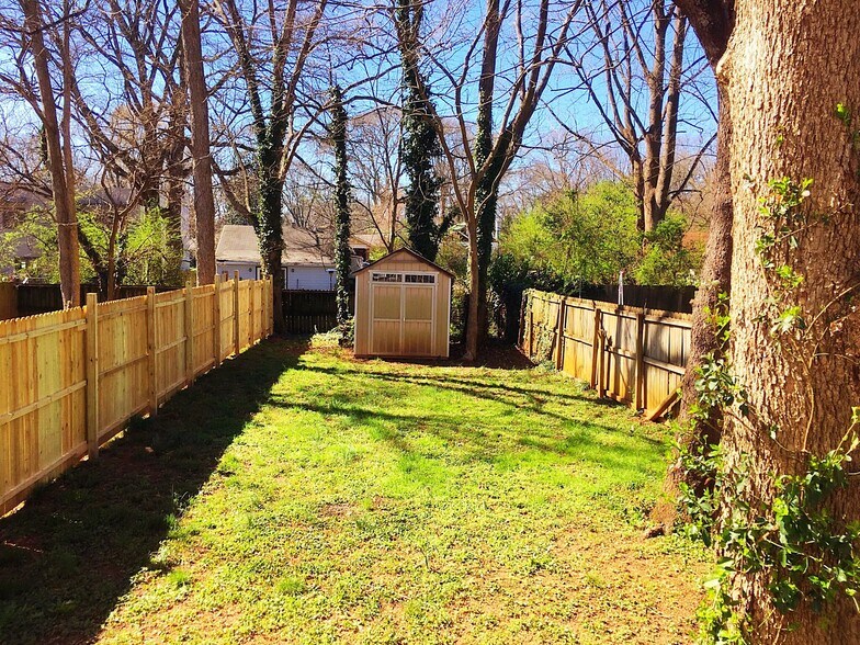 A view of the yard from the porch. The first unit to rent can elect if they want a shed. The shed is fully enclosed and can be used partially by the tenent - 190 Hutchinson St NE