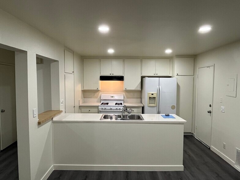 Dining Area Looking into Kitchen with Quartz Countertops and dimmable resessed lights - 1103 W Francis St