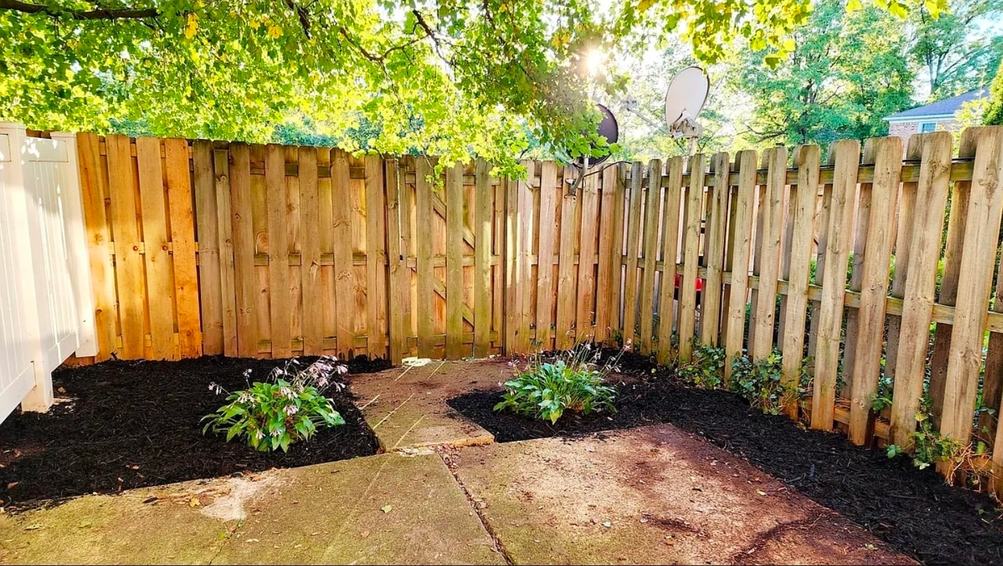 Private fenced patio with fresh landscaping, garden beds, and shaded greenery—perfect for relaxing o - 21 Richmond Sq