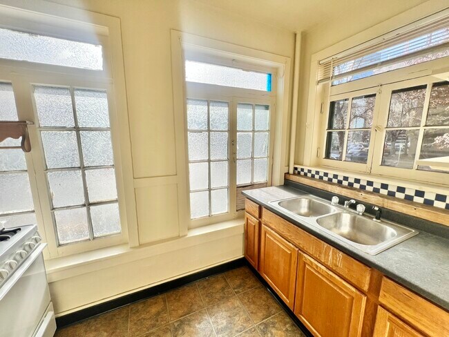 Experience the warmth and light in this welcoming kitchen space, perfect for culinary inspiration. - Cross Apartments