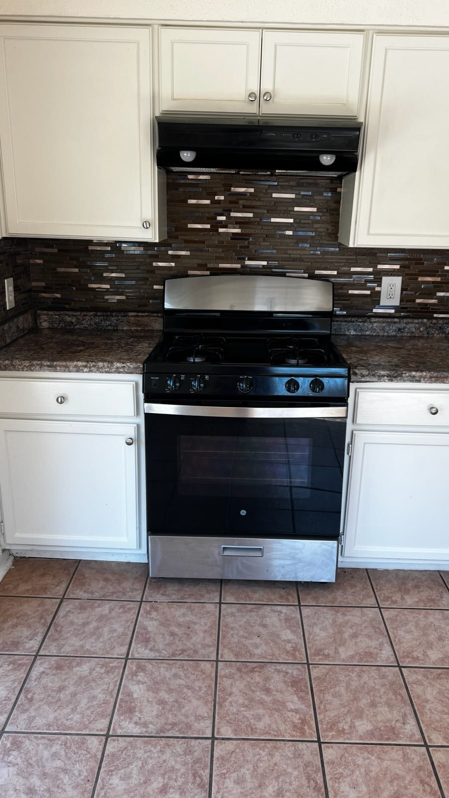 Kitchen featuring stainless steel gas range oven, light tile patterned floors, white cabinetry, and - 5906 Wagon Bnd