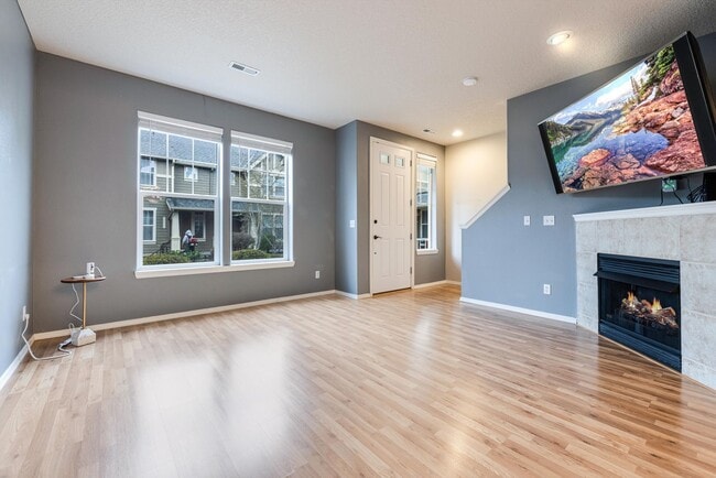Building Photo - Lovely and bright townhouse with a hard wood flooring throughout, a 2 car garage, AC & more!