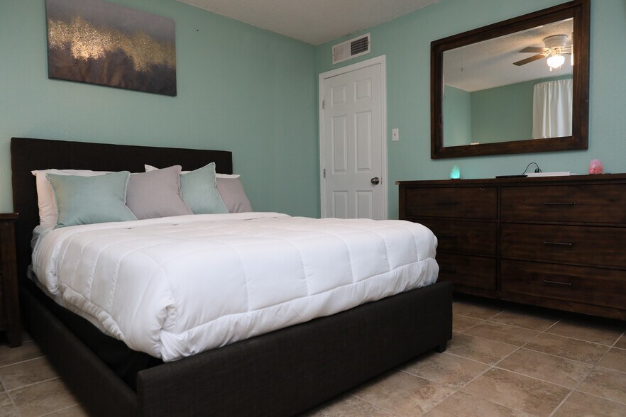 This comfy queen sized bed is comfy thanks to its new mattress and topper. - 8612 Echo St