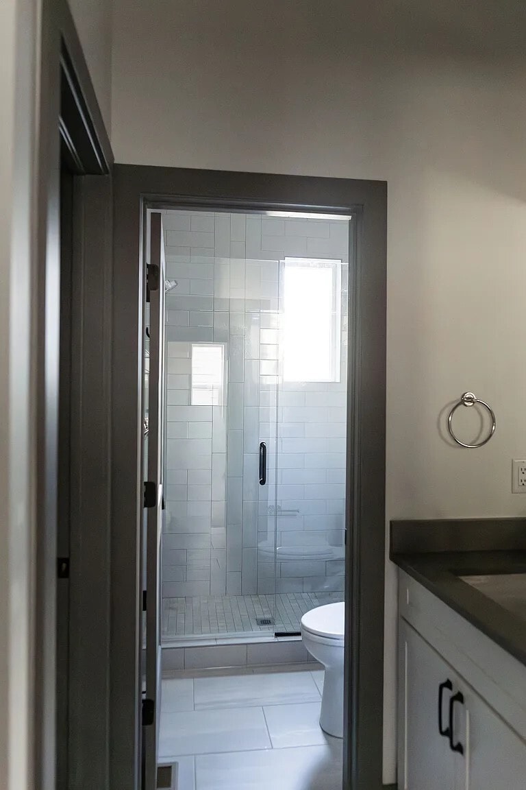 Primary Bathroom with dual sink vanities, a walk-in closet, and a stand up shower - 3505 S Marion St