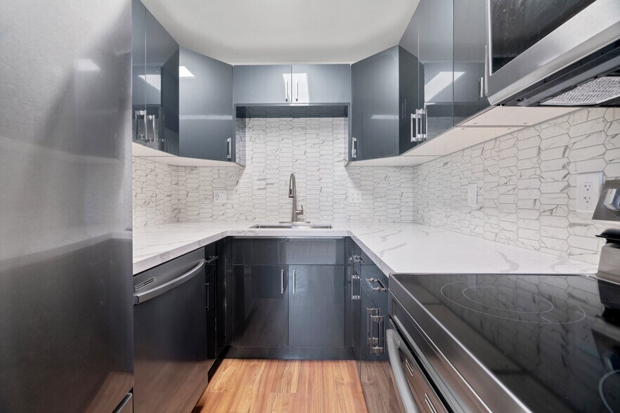 Open-concept renovated modern kitchen with all new stainless steel appliances - 411 124th St S