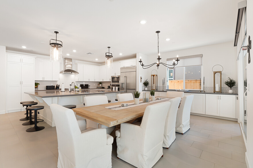 Large kitchen/dining w/ Pottery Barn chandelier in dining area, & decorative lighting above island. - 5919 Lakestone Dr