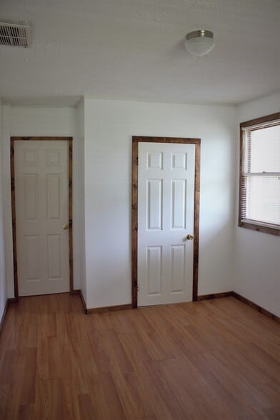 Downstairs bedroom, two windows, newer walls, newer paint, newer flooring, and closet. - 9331C Tallmadge Road