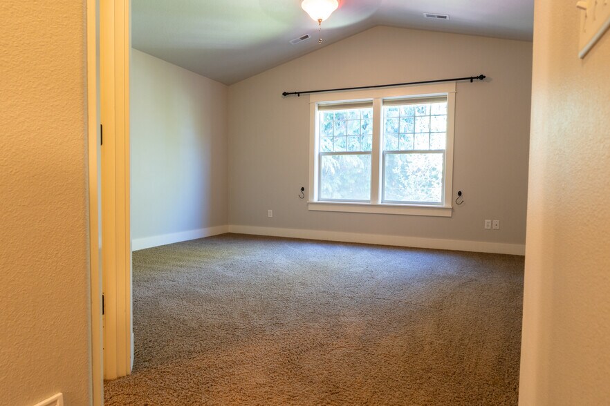 Primary Bedroom with Vaulted Ceiling - 7921 N Denver Avenue