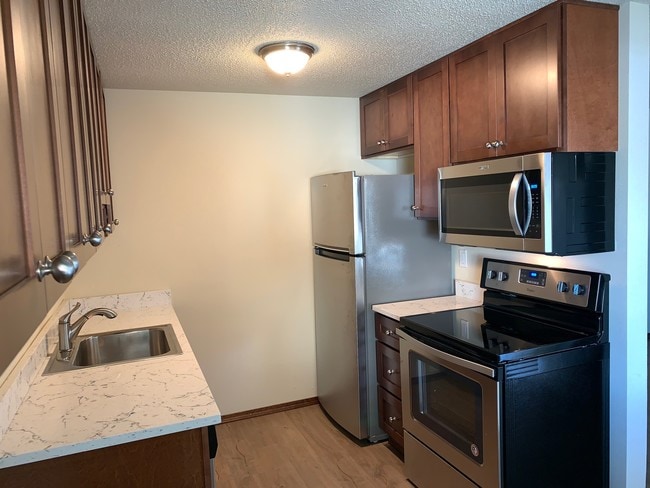 Quartz counters and stainless appliances - Pearl Manor Apartments - 55+ Senior Living