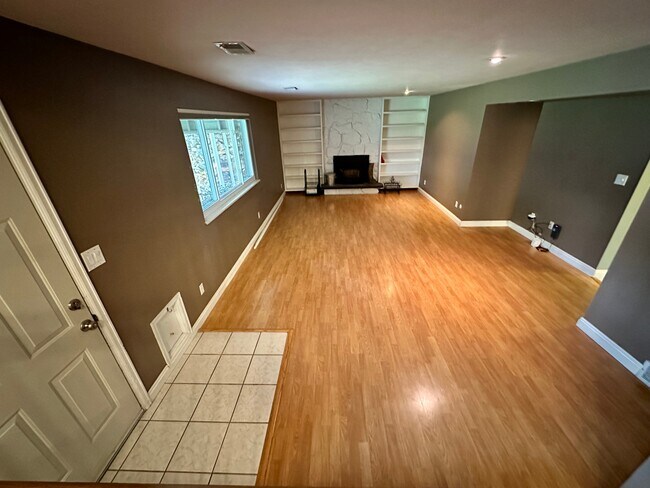 Family room with wood-burning fireplace and built-in bookcases - 7393 S Washington Cir