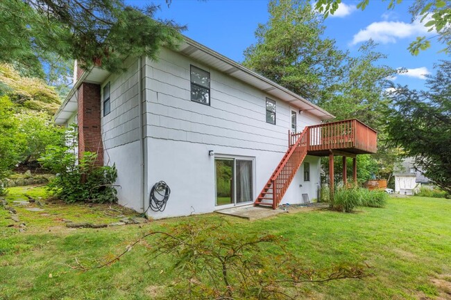 Expansive backyard with lush green and large trees providing ample shade. - 45 High St