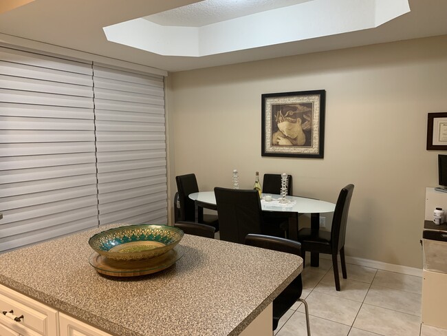 Dining room with lake view and zebra blinds - 11549 NW 62nd Ter