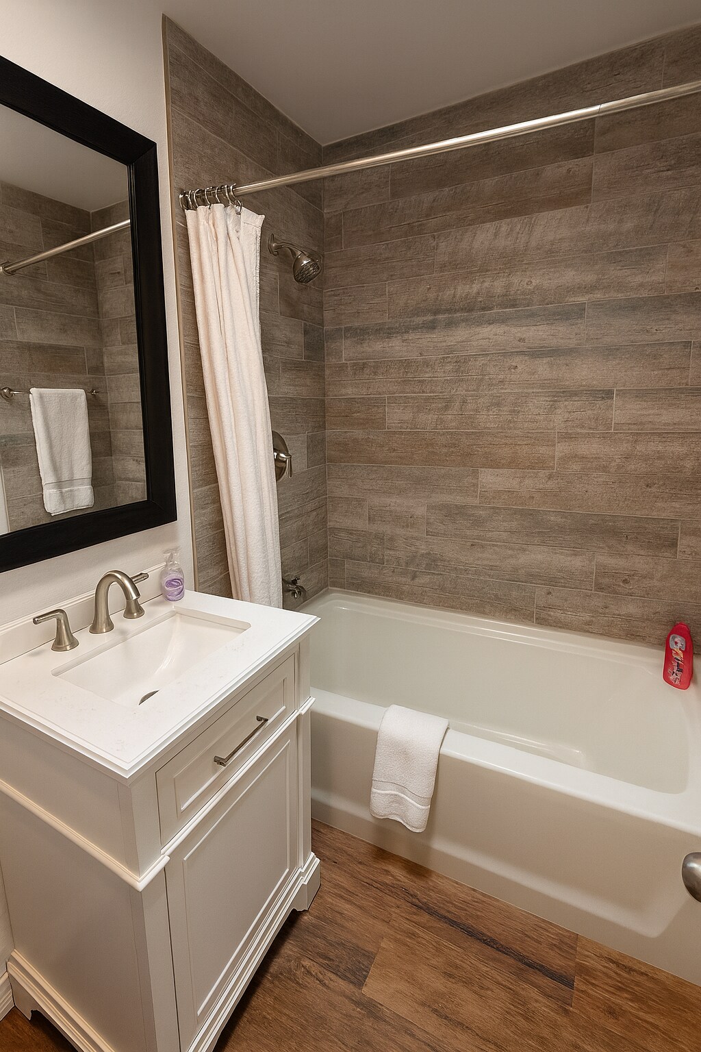 Stylish shared bathroom with shower/tub combo and separate vanity area. - 10116 Mercedes St