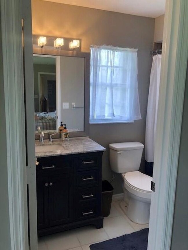 Primary bathroom has newer vanity with granite and large tiled shower. - 2321 SE 5th Ct