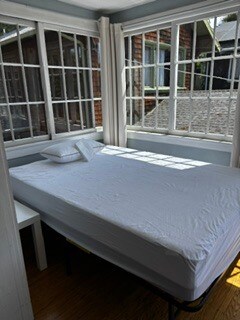 Bed and table in sunroom/bedroom - 2615 Parker St