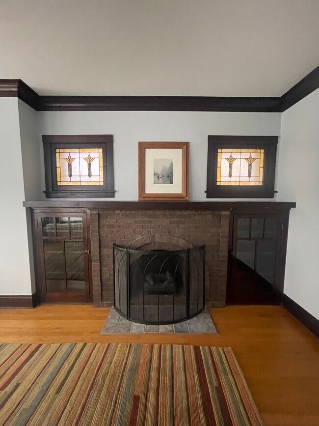 Fireplace with vintage stained glass and enclosed bookcases - 5735 N Washtenaw Ave