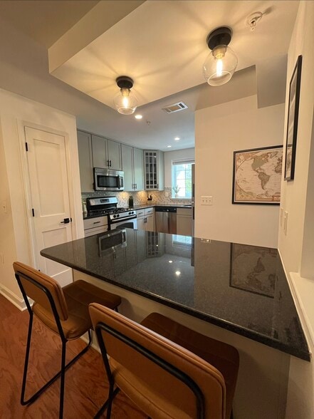 The granite peninsula is perfect for quick meals or working from home. - 4079 S Four Mile Run Dr