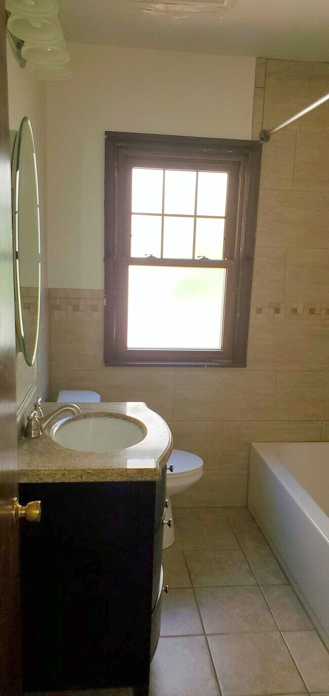Full bathroom with updated finishes and natural light. - 2923 Arthur St NE