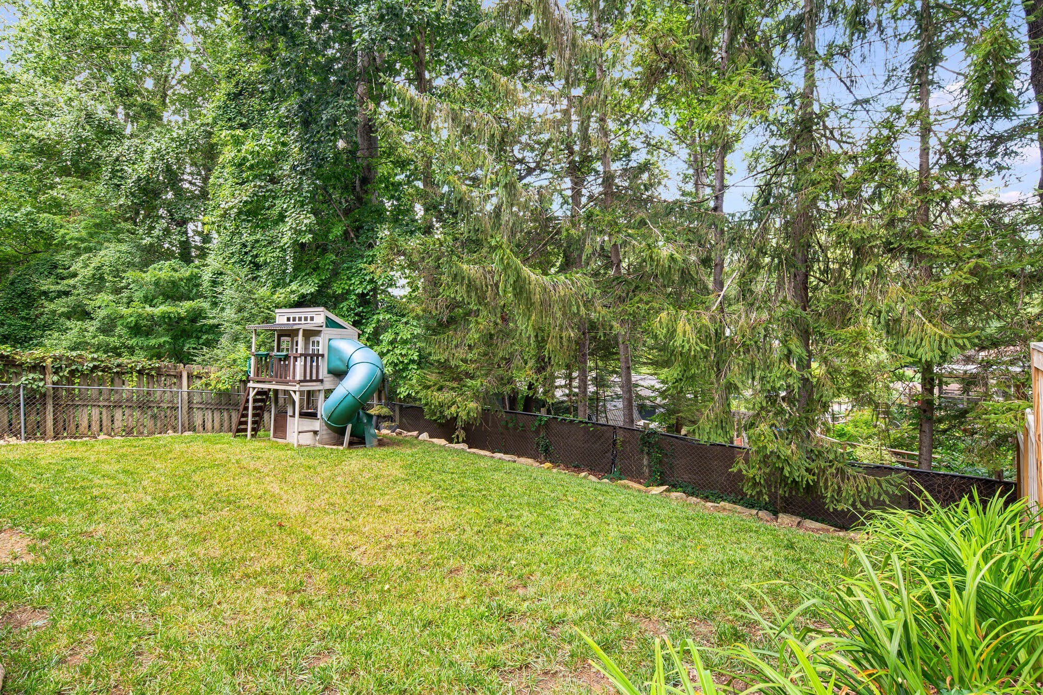 Lower terrace in back yard with year-round evergreen trees as backdrop for privacy. - 33 Rex Dr