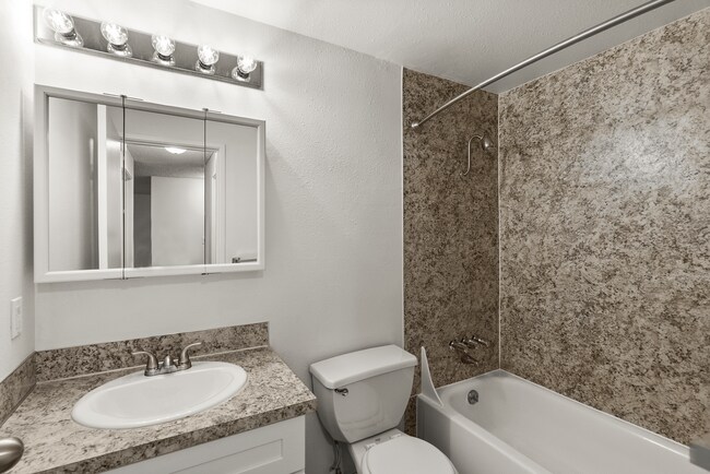 Start and end your day in a clean, modern bathroom featuring stylish finishes, ample mirror space, and a full bathtub and shower. - Bay Ridge Apartments