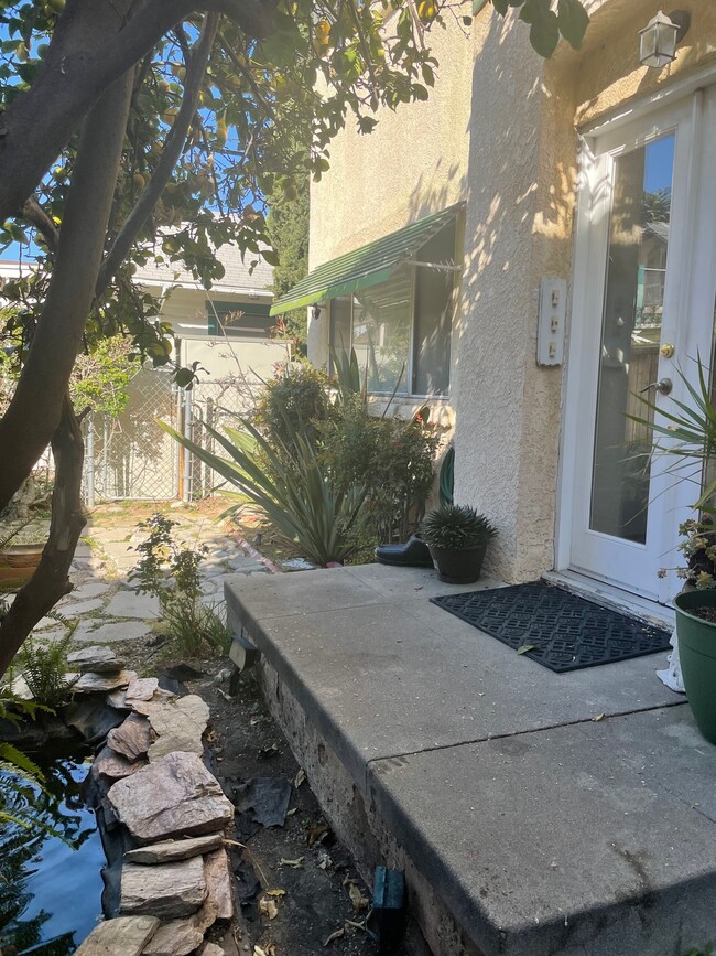 Triplex front porch. View looking West. Triplex entry door on right. Pond and lemon tree on left! - 1749 E 3rd St