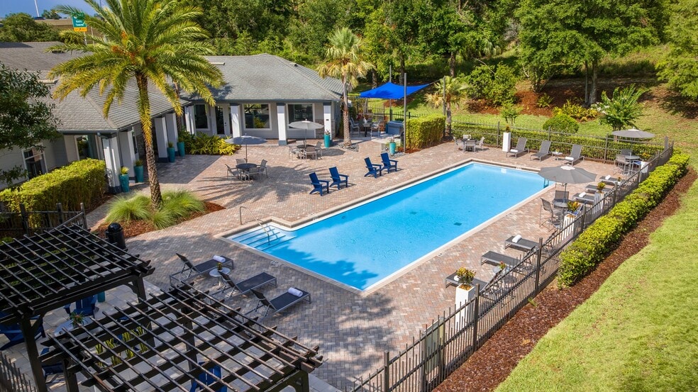 Surrounded by lush greenery and modern lounge seating, the Elevate 155 pool offers the ultimate space to relax, recharge, and soak up the Florida sunshine. - Elevate 155