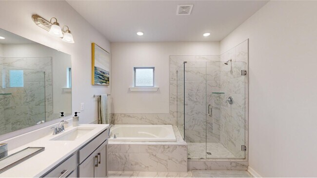 Glass-enclosed shower & tub features stylish ceramic tile surround that harmonizes with the flooring - 15580 Ruthie Lynn Dr