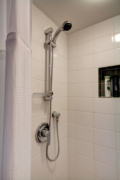 Tiled shower with recessed shampoo niches (in both bathrooms), and Grohe shower hand shower with shower bar - 535 Summit Ave E
