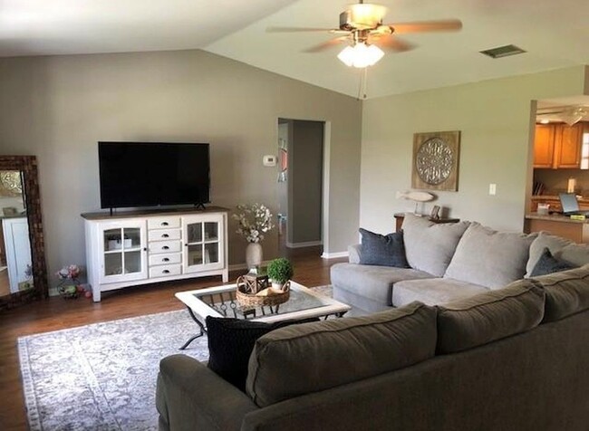 Open concept living room with vaulted ceiling and ceiling fan. - 2321 SE 5th Ct