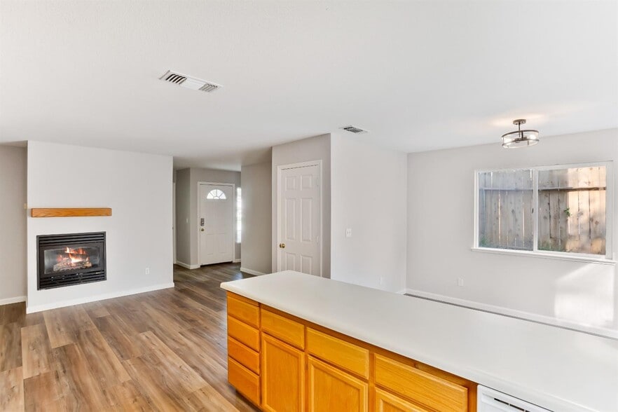 The view of the family room & dining room from the kitchen. - 3038 Courtside Dr