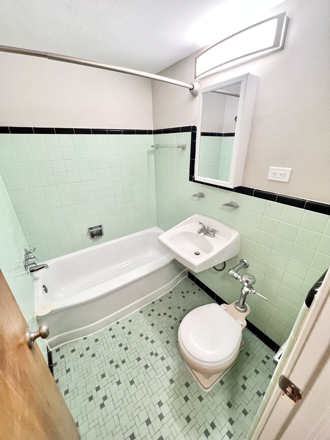 Experience vintage charm with modern comfort in this beautifully designed bathroom space. - The Birney Apartments