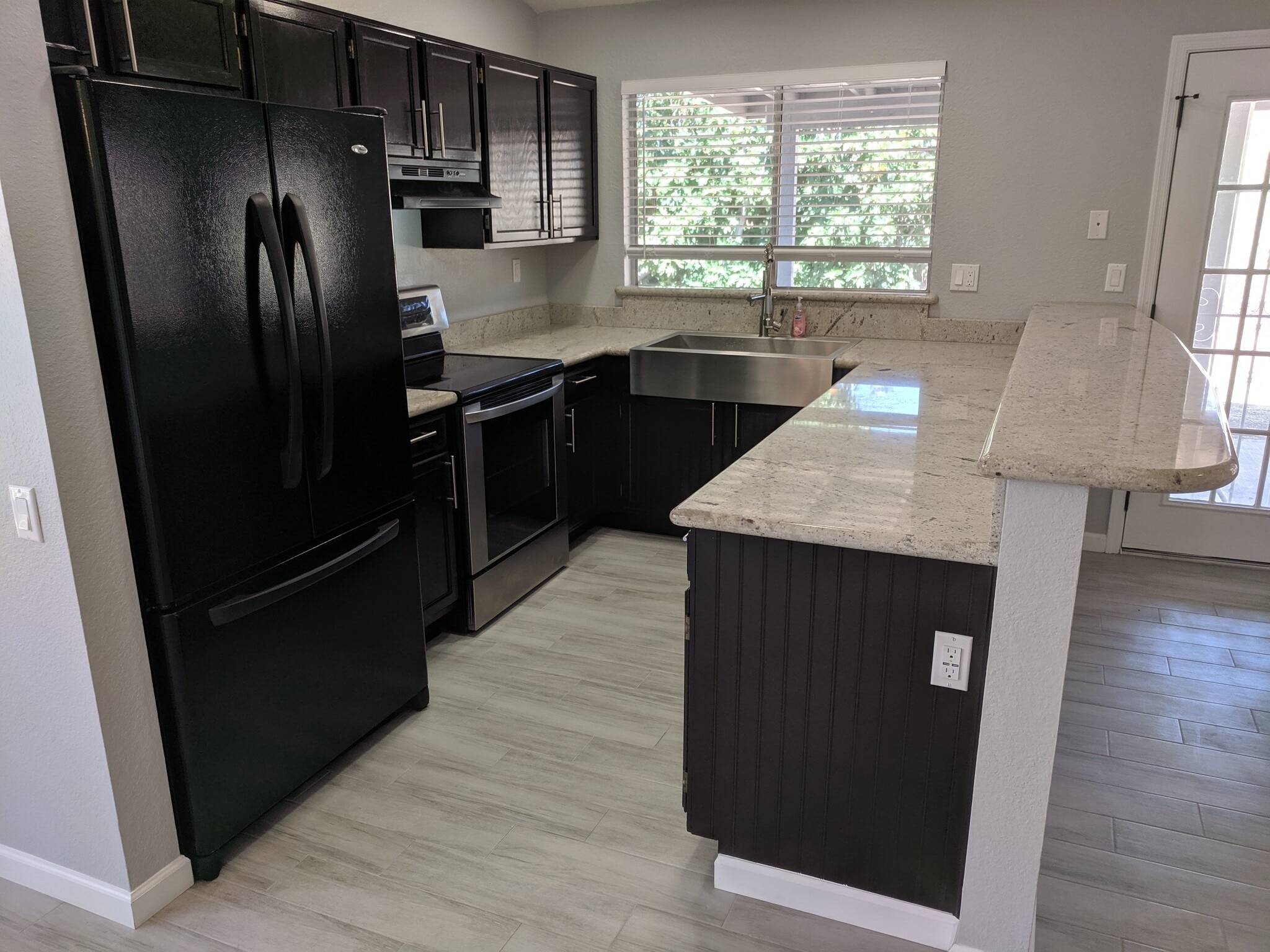 Kitchen with Fridge, Dishwasher, and Stove with Hood. Farmhouse stainless steel front apron sink, granite counter tops - 14101 N 78th Dr