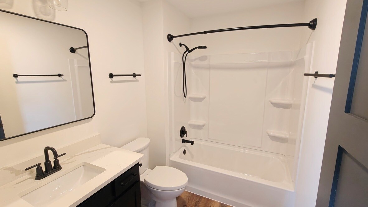 Second bathroom located just outside of guest bedroom. Features vanity and shower/tub combo - 101 W Broadway St