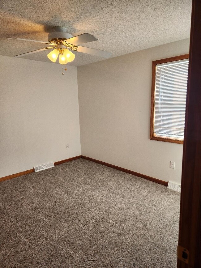 Smaller bedroom with new carpet and window blinds. - 6568 Ward Rd