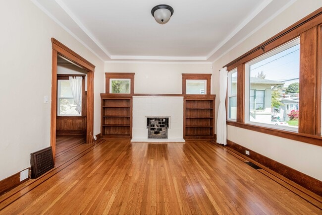 Living room with natural light, built ins, entry closet and security system. - 431 Athol Ave