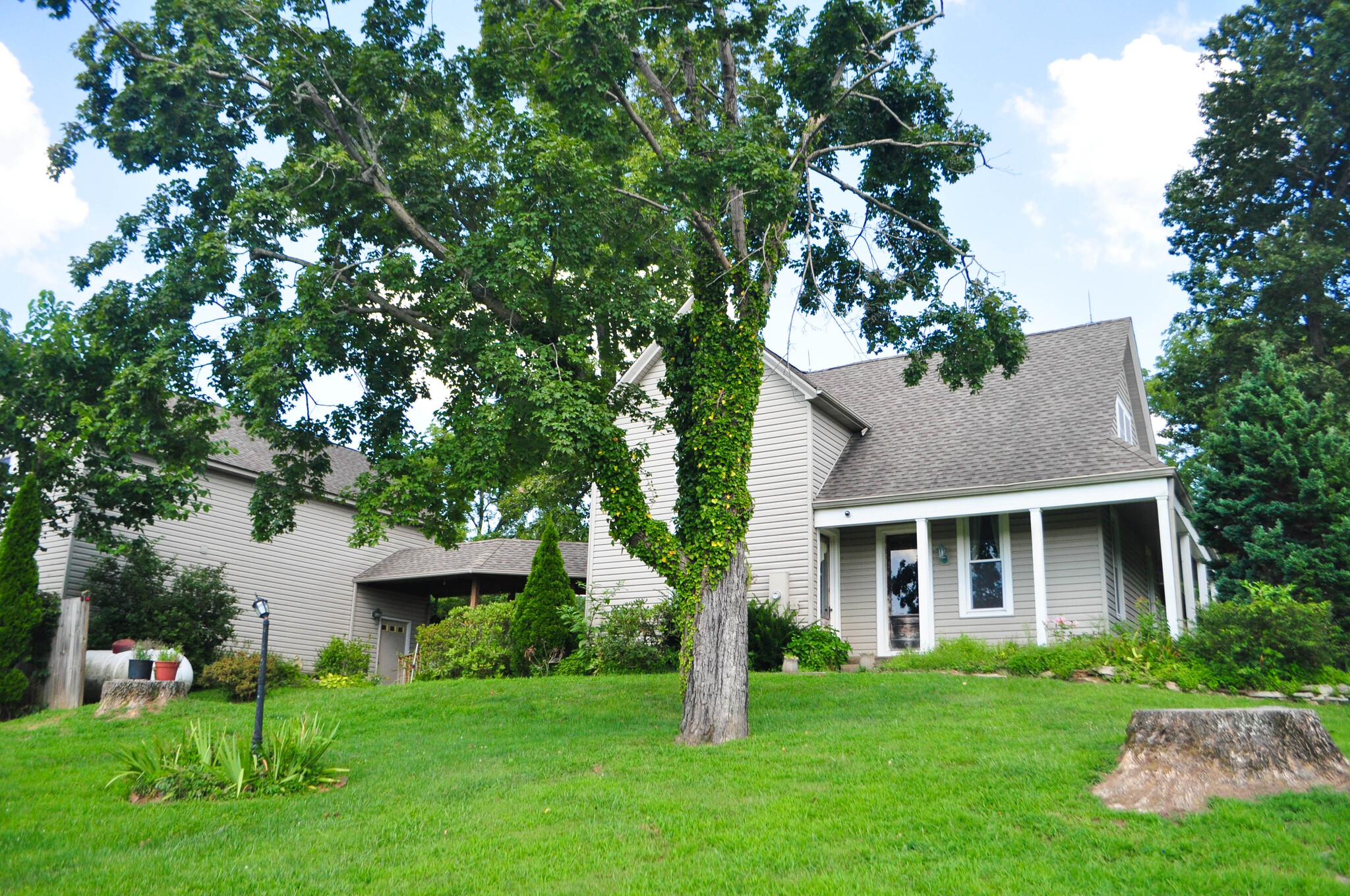 View coming up driveway of home, covered walkway and detached garage - 7502 Borden Rd