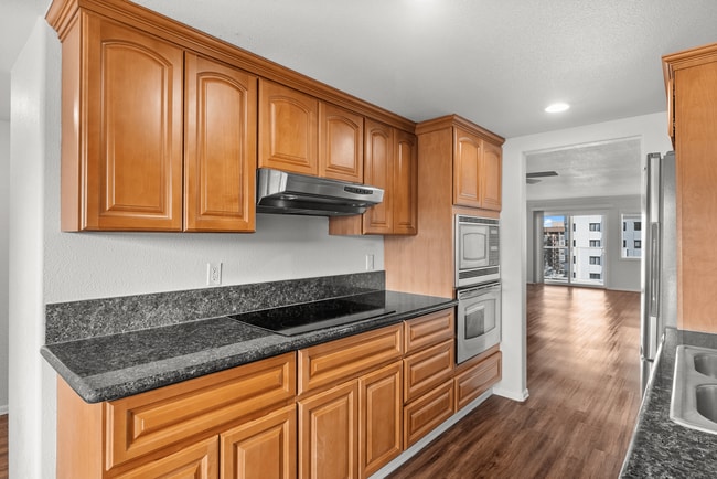 Explore this elegant kitchen with ample cabinetry and a seamless transition to the living space. - Vista Terrace Apartments