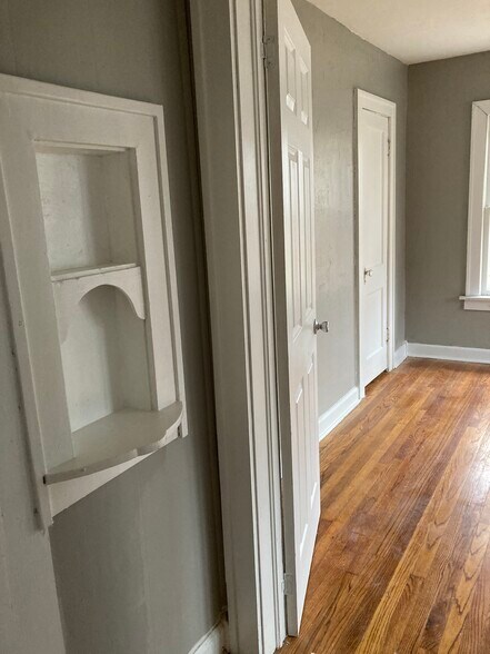 Looking into back bedroom, small hallway with original built in phone nook. - 1503 N Broadway Ave
