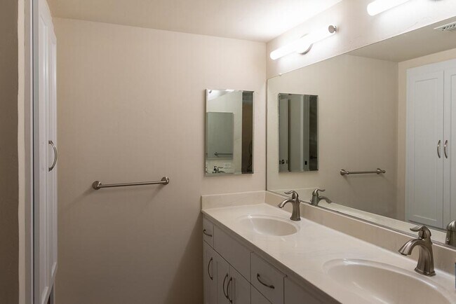 Bedroom 1's ensuite bathroom with double sinks and linen storage - 500 N St