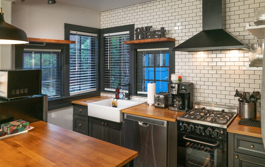 Kitchen with dishwasher, gas range, microwave, fridge, coffee maker, and toaster - 1285 62nd St