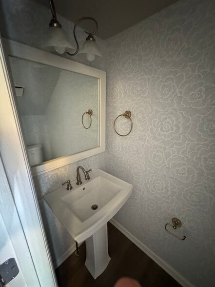 First floor powder room with new wallpaper, pedestal sink and large mirror - 2312 18th Ave S