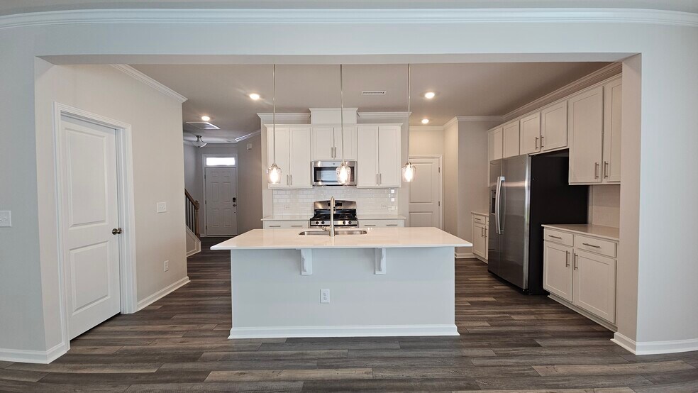 View from living room into kitchen, with new Pendant Lights installed. Fridge installed to the right - 2207 Cape May Ln
